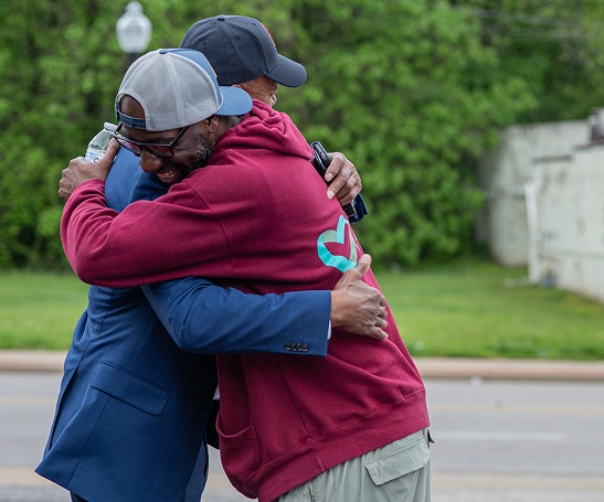 Community Ambassador hugging a community member